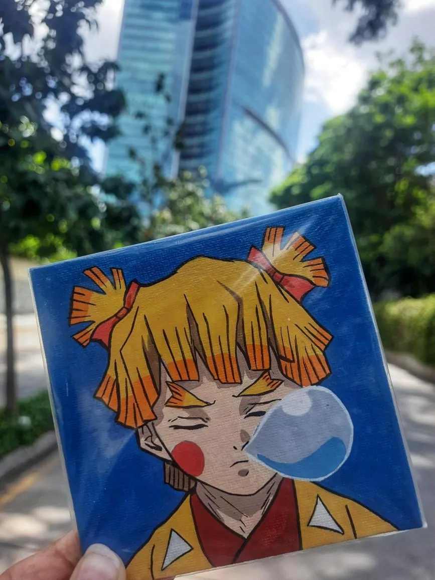 Hand-painted acrylic mini canvas of Zenitsu Agatsuma from Demon Slayer against a blue background, photographed outdoors.