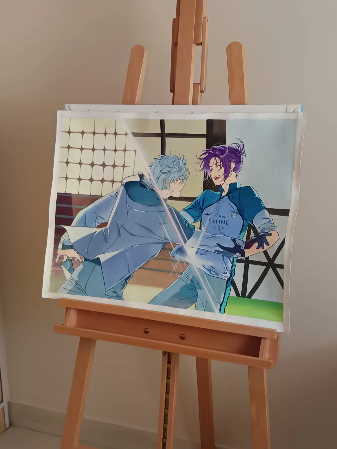Blue-toned hand-painted sports anime duo canvas on a tabletop easel.