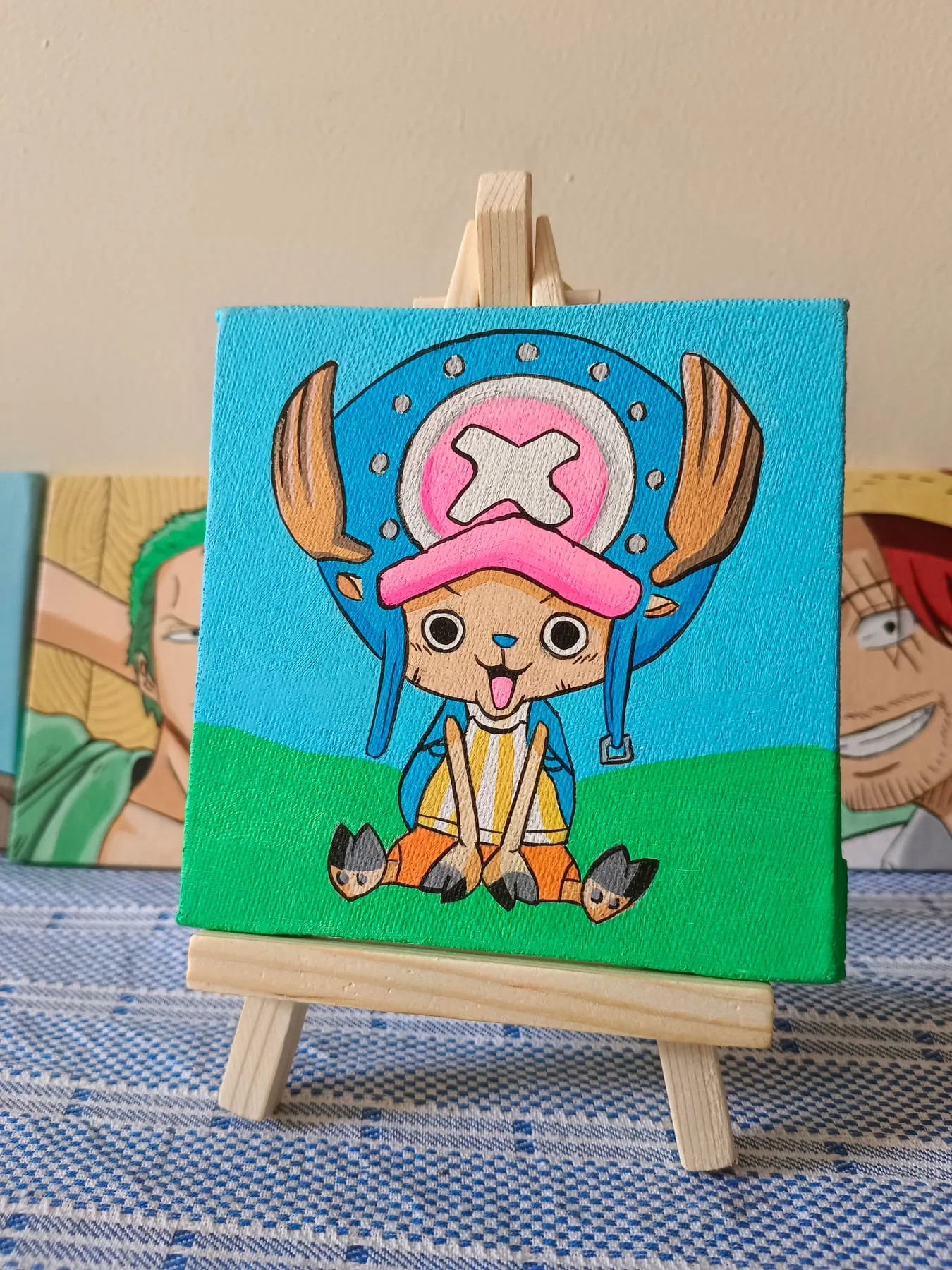 Hand-painted acrylic mini canvas of Tony Tony Chopper from One Piece on a teal background, displayed on a small easel.