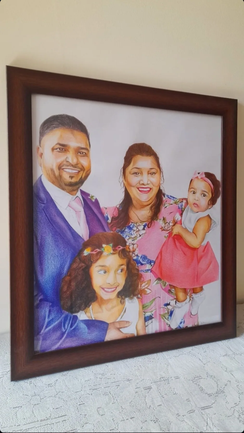 Framed colour-pencil family portrait with four people, drawn from a photograph.