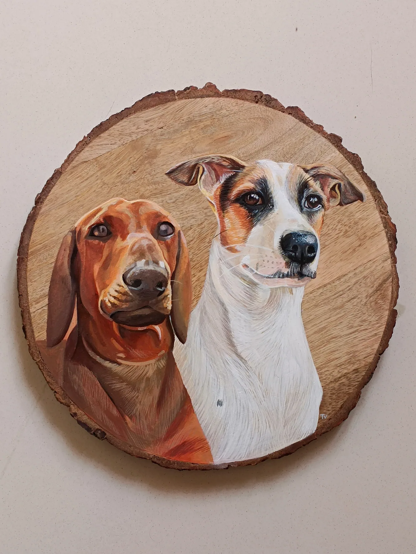Round wood slice painting of two dogs side by side, a warm custom pet portrait with natural bark edge detail.